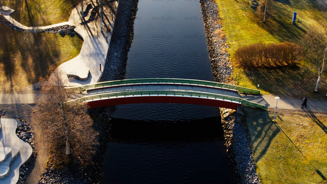 Autumn aerial view: Person walking across a bridge over Piteå city canal