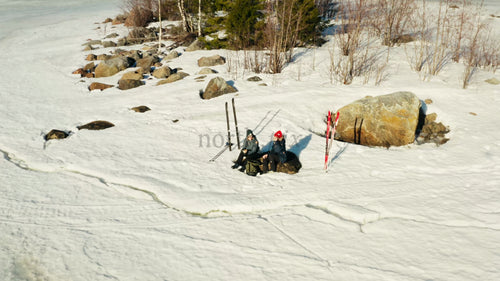 Vinterskidåkning i Luleå, Sverige: Flygfoto från drönare över skidåkare som vilar på en frusen sjöö