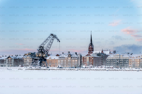 Industrial crane and church spire on snowy waterfront