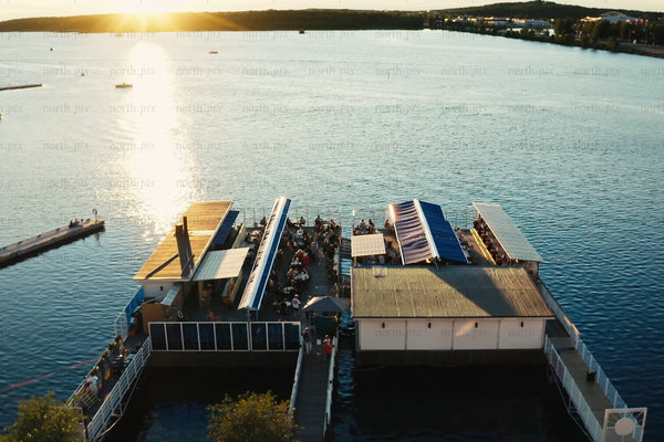 Luleå city center waterfront floating restaurant at sunset with people dining and boats