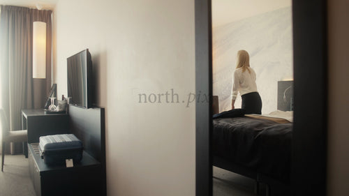 Affärskvinna anländer till modernt hotellrum i Luleå, Sverige, och kopplar av i sängen