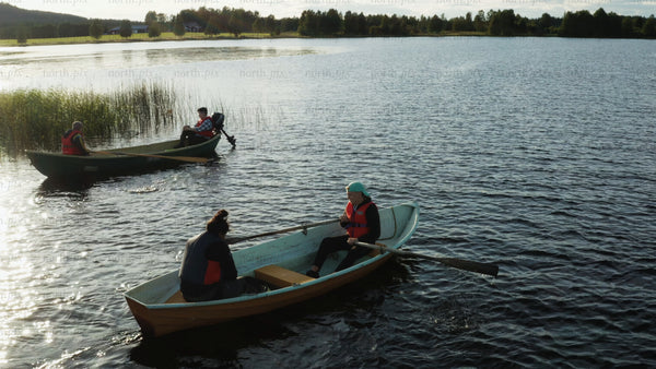 Summer evening boating and rowing on a calm lake in Luleå